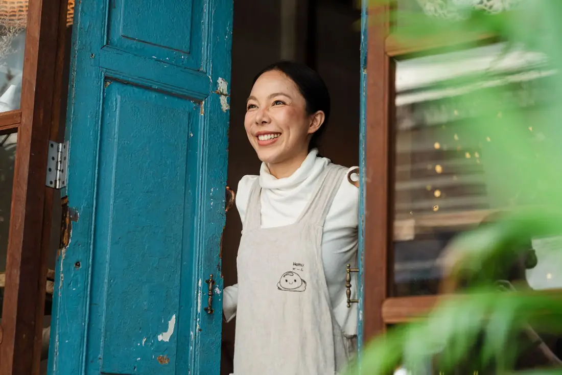 A smiling shop owner in her doorway